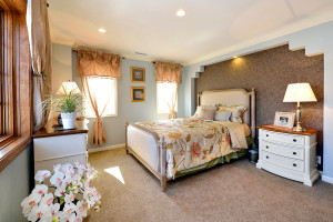 ベッド頭部側のニッチとモールディングが特徴のベッドルーム。家具やカーテン、インテリア小物に至るまでトータルコーディネイト